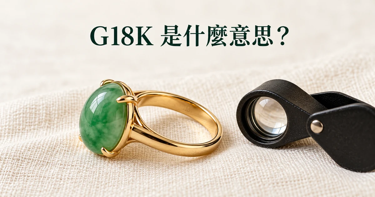 米白亞麻布上一枚黃金鑲嵌的綠色翡翠蛋面戒指側放,露出戒圈內側,旁邊一把珠寶放大鏡,柔和自然光