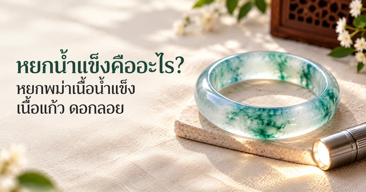 กำไลหยกพม่าเนื้อน้ำแข็งใสมีลายดอกลอยสีเขียวอมฟ้า วางบนผ้าลินินสีงาช้างในแสงธรรมชาตินุ่มๆ ข้างไฟฉายเล็ก