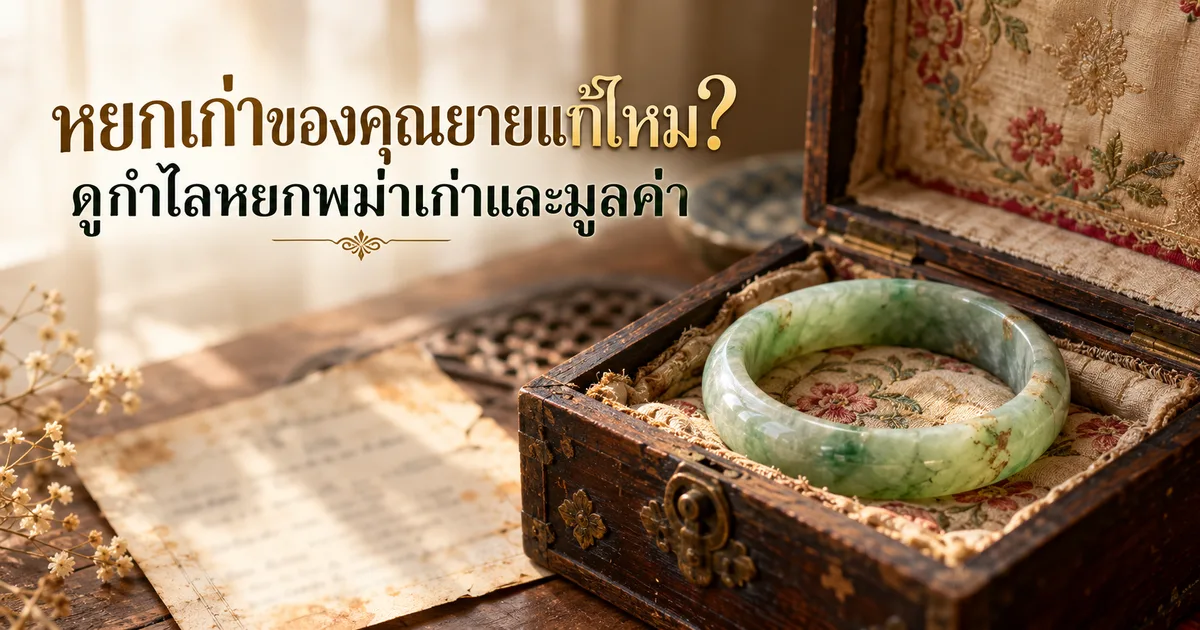 กำไลหยกพม่าเก่าสีเขียวอ่อนที่สึกแล้ววางบนผ้าปักสีซีดในกล่องเครื่องประดับไม้ที่เปิดอยู่ พร้อมชื่อเรื่อง หยกเก่าของคุณยายแท้ไหม? ดูกำไลหยกพม่าเก่าและมูลค่า