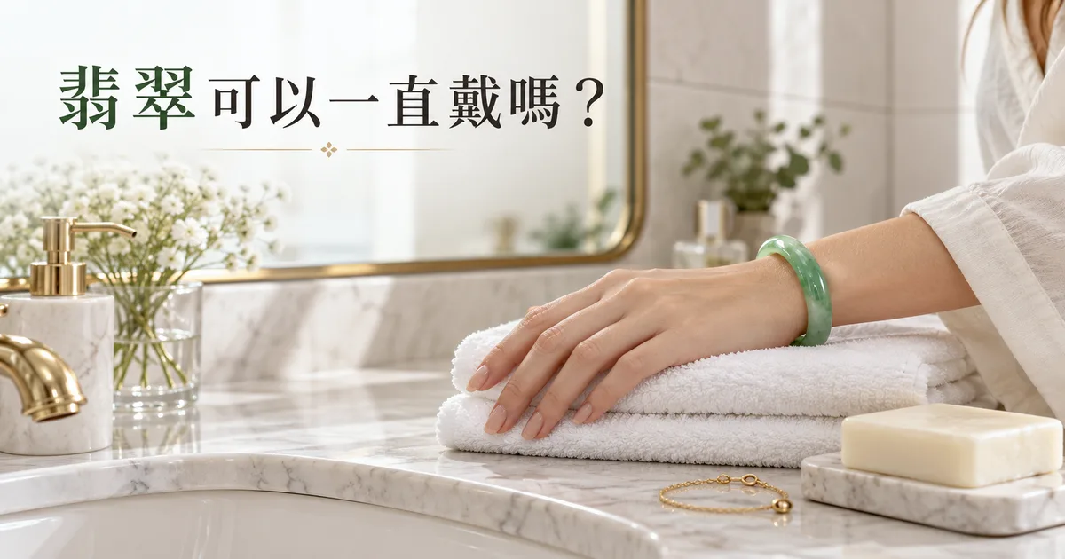 浴室洗手檯邊疊好的白毛巾上,一隻戴著綠色翡翠手鐲的手,旁邊放著香皂和金手鍊,配標題「翡翠可以一直戴嗎?」